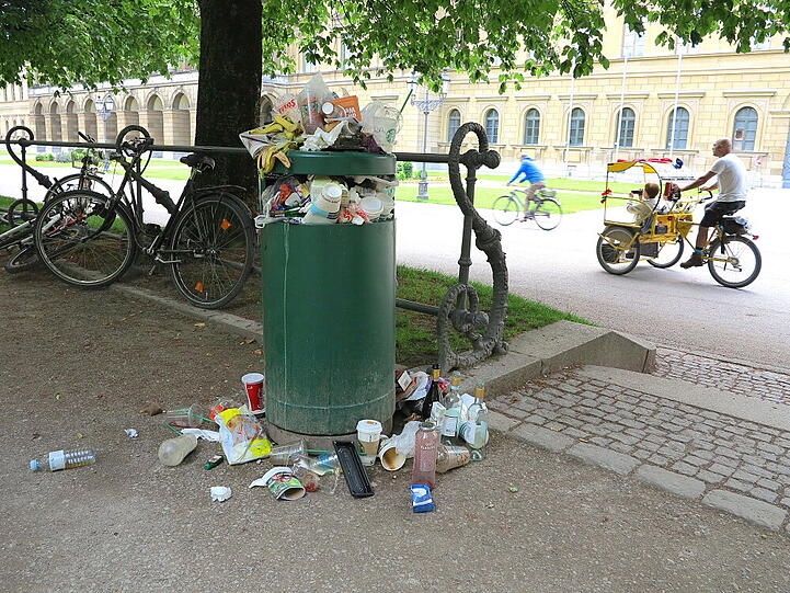 Am Wochenende zieht es die Münchner in die Parks. Ihren Müll drapieren sie derweil kunstvoll um die überquellenden Eimer im Hofgarten.