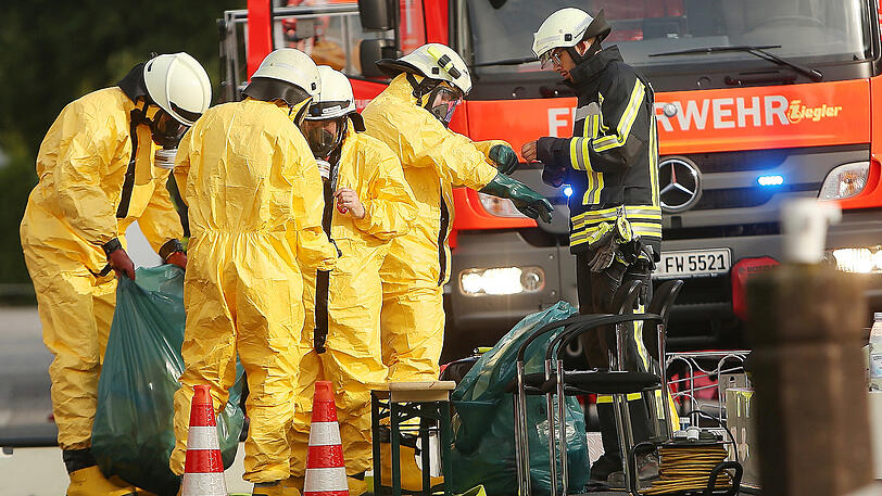 Feuerwehrleute und Helfer vor dem Firmengebäude in Langenfeld in dem es zu einem Chemieunfall gekommen ist.