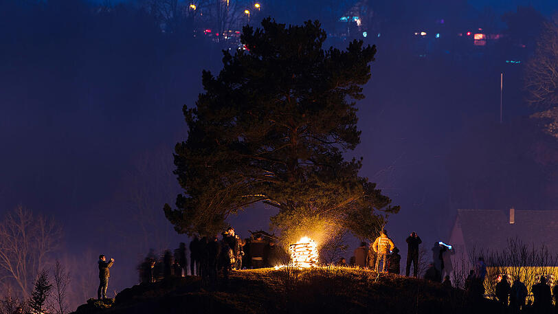 Beeindruckende Bilder: Zahlreiche Besucher stehen am Samstag nahe der Burg Pottenstein in der Stadt Pottenstein und blicken auf hunderte Bergfeuer. Grund ist das katholische Fest der Ewigen Anbetung.