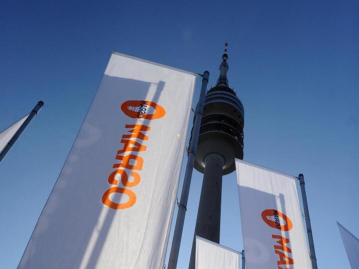 Fahnen mit Osram-Logo sind in München (Bayern) vor dem Olympiaturm aufgestellt. Foto: Tobias Hase/Archiv
