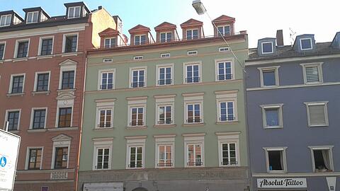 Etwas verblasst, aber dennoch zu erkennen: Der alte Schriftzug an einem Haus am Rosenheimer Platz.