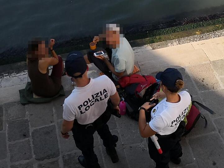 Erwischt: Die beiden deutschen Touristen werden von Polizisten an der Treppe der Rialto-Brücke angesprochen.