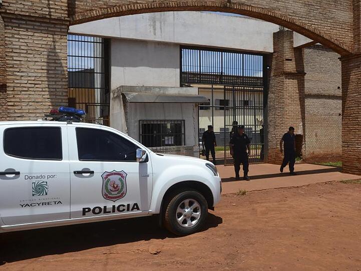 Polizisten stehen vor dem Eingang des Gefängnisses in Paraguay, aus dem bei einem Massenausbruch 75 Häftlinge getürmt sind.