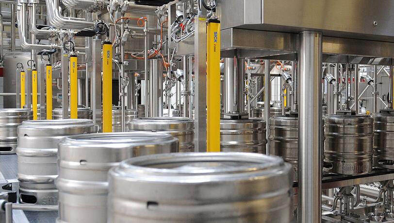Bier wird in einer Brauerei in einer Abfüllanlage in Bierfässer gefüllt.