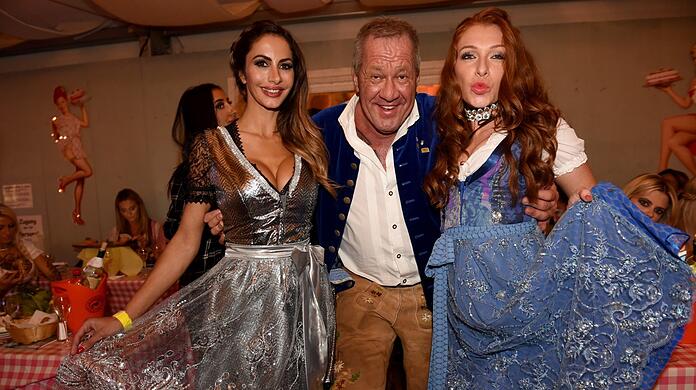 So kennen ihn die Münchner: Hugo Bachmaier mit guter Laune und schönen Frauen im Arm (hier: Model Janina Youssefian und Reality-TV-Sternchen Georgina Fleur; r.).