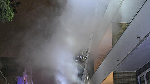 Einsatzkräfte der Feuerwehr München drangen, geschützt durch schweren Atemschutz, in die Wohnung im dritten Obergeschoss.