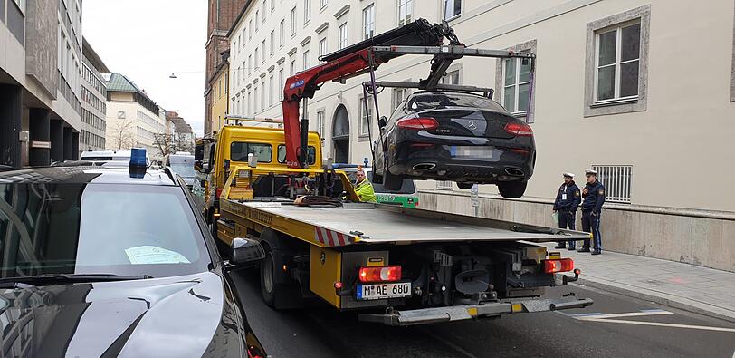 In der Maxburgstraße wird ein Mercedes abgeschleppt.