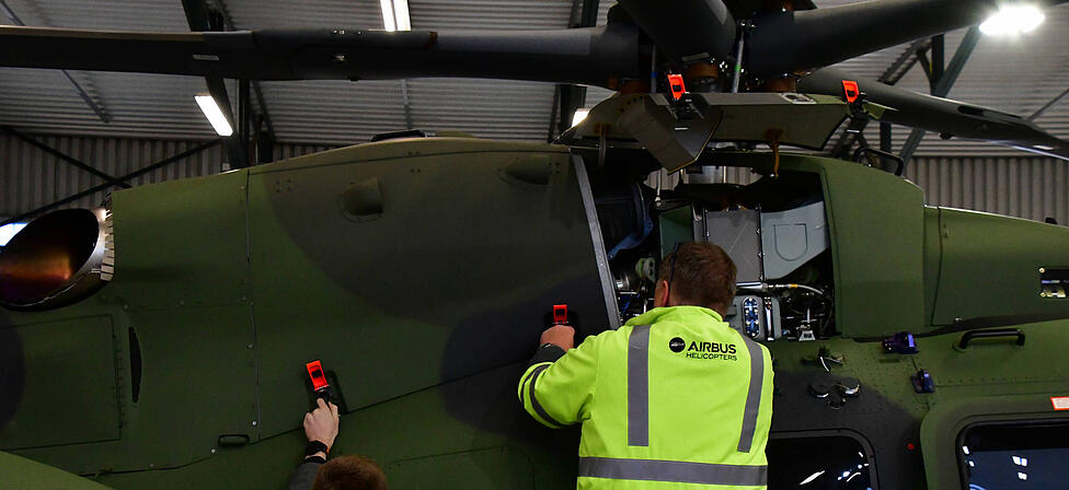 Mitarbeiter von Airbus halten einen Leichten Kampfhubschrauber (LKH) instand. Die in Taufkirchen angesiedelte Defence-Sparte des Unternehmens setzte im Jahr 2025 13,4 Milliarden Euro um.