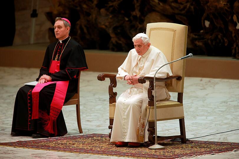 Papst Benedikt XVI. sitzt in der Audienzhalle Paolo VI im Vatikan bei seiner voraussichtlich letzten Generalaudienz neben seinem Sekretär Georg Gänswein (links). Es ist das erste Mal, dass sich der Pontifex nach seiner historischen Rücktrittankündigung vom Montag den Gläubigen zeigt. Die Bilder.