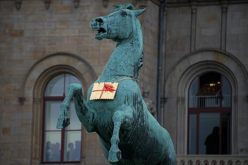 ...Die Wende im Keks-Krimi: Anfang Februar wurde vor Hannovers Leibniz Universität der Keks gefunden. Mit einer roten Schleife verziert, hing er an einer Kette am Hals des Niedersachsenpferd-Denkmals. Im Juli wurde das Kunstwerk neu vergoldet wieder an seinen Platz gehängt &ndash; jetzt übrigens mit Kameraüberwachung.