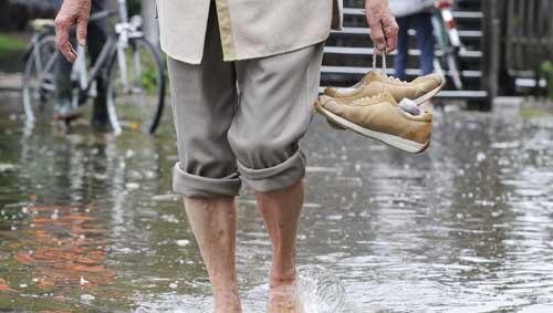 Eine Frau traegt am Samstag (07.08.10) in Starnberg (Bayern) ihre Schuhe, waehrend sie barfuss durch das Wasser läuft. Eine Frau traegt am Samstag (07.08.10) in Starnberg (Bayern) ihre Schuhe, waehrend sie barfuss durch das Wasser läuft.