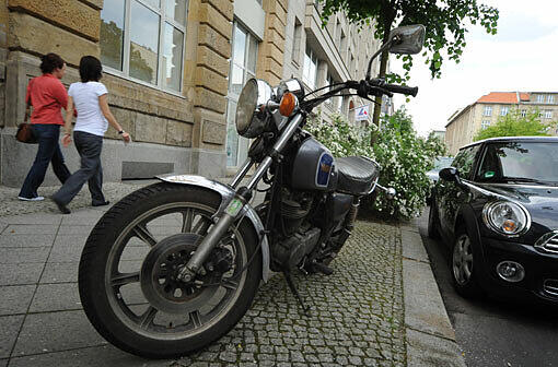 Weil Pkw-Parkplätze oft knapp sind, tolerieren die meisten Ordnungsbehörden auf dem Gehweg abgestellte Motorräder.