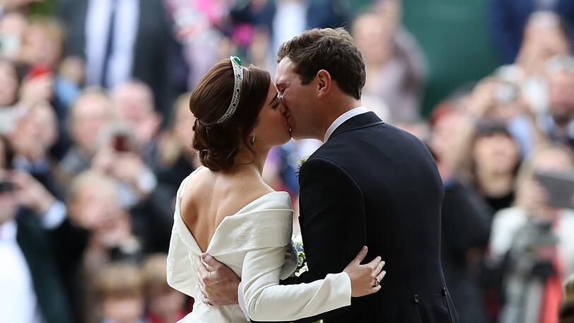 Prinzessin Eugenie und ihr Ehemann Jack Brooksbank küssen sich, als sie nach ihrer Hochzeit die St. George's Chapel in Schloss Windsor verlassen.