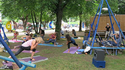 "Wisdom, Beats & Poses": Das ist Yoga mit lässiger Musik-Begleitung im "Garten der fliegenden Wolken" auf dem Tollwood-Gelände.