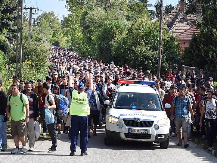 Ungarische Polizisten begleiten am 19.9.2015 einen Flüchtlingszug durch Hegyeshalom (Ungarn) zur Grenze nach Österreich.