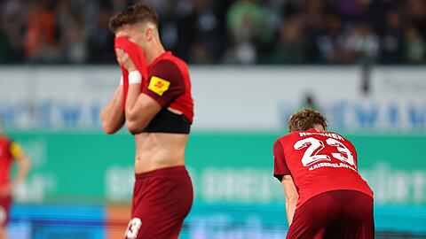 Jan Elvedi (l) und Philipp Hercher aus Kaiserslautern stehen nach dem Abpfiff auf dem Platz.