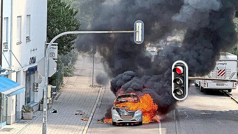 Der Peugeot steht in Flammen, schwarzer Rauch steigt in Pasing an der Kreuzung Gr&auml;f- und Beckerstra&szlig;e auf.