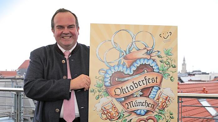 Clemens Baumgärtner (CSU) hält das Siegermotiv für das Oktoberfest-Plakat 2021 in den Händen. Jetzt kann für das Motiv 2022 abgestimmt werden.