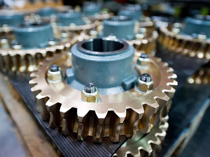 Schneckenräder, Teile eines Getriebes, liegen in einer Produktionshalle. Foto: picture alliance / dpa/Symbolbild