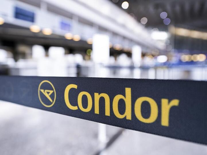 Das Condor-Logo auf einem Absperrband vor einem geschlossenen Schalter.