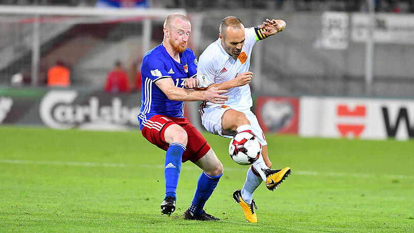 "Es ist einfach der Wahnsinn, sich mit den besten Spielern der Welt zu messen", sagt Liechtensteins Büchel (l.), hier gegen Spaniens Iniesta.
