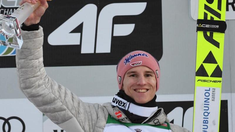 Karl Geiger, Skispringer aus Deutschland, jubelt bei der Siegerehrung über den zweiten Platz. Foto: Angelika Warmuth/dpa Karl Geiger, Skispringer aus Deutschland, jubelt bei der Siegerehrung über den zweiten Platz. Foto: Angelika Warmuth/dpa