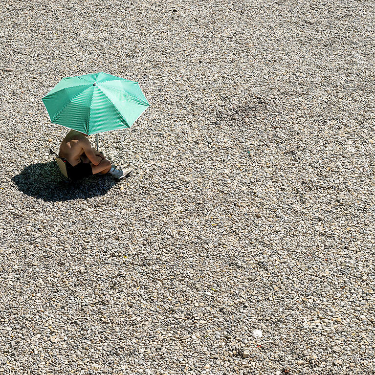 Ein Mann sitzt auf einer Kiesbank am Ufer der Isar: Ein Wetter-Experte ordnet ein, wie ernst die D&uuml;rre in M&uuml;nchen und dem Umland ist.