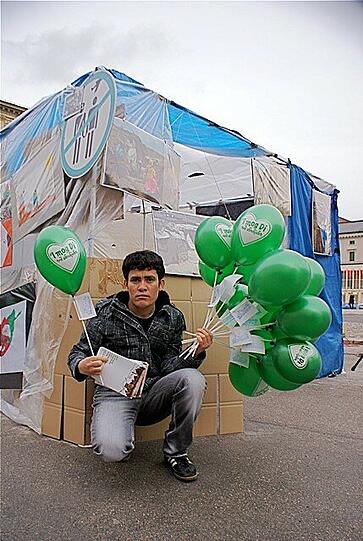 Auch dieser Mann demonstriert und verteilt Luftballons.