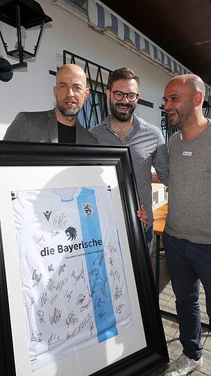 Die Löwen-Geschäftsführer Günther Gorenzel (links) und Michael Scharold (rechts) überreichten Benedikt Lankes ein Trikot mit den Unterschriften der 1860-Profis.