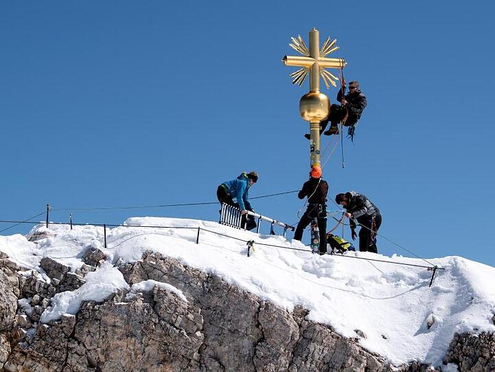 Schlosser bei Reparaturarbeiten am Gipfelkreuz auf der Zugspitze. Foto: Sven Hoppe