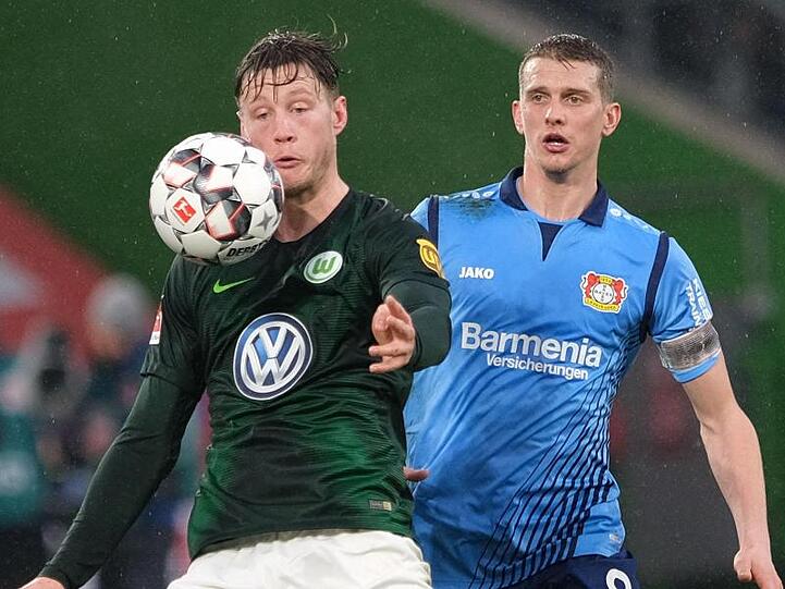 Leverkusens Lars Bender (r) und Wolfsburgs Wout Weghorst (l) kämpfen um den Ball. Foto: Peter Steffen/Archiv