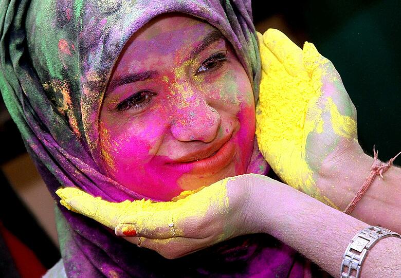 Die Menschen beschmieren sich von oben bis unten mit Farbe, aber besonders viel Spaß macht es, sich die Farbe gegenseitig im Gesicht zu verstreichen.