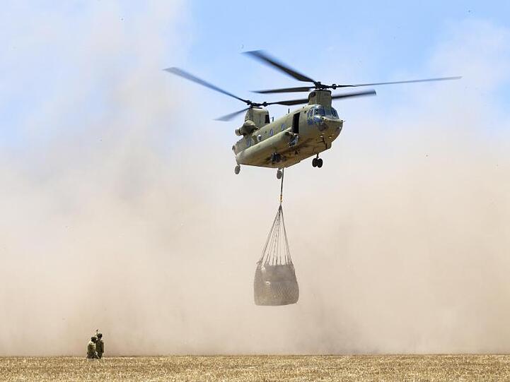 Ein Transporthubschrauber bringt Heuballen als Tierfutter zu entlegenen Farmen auf Kangaroo Island.