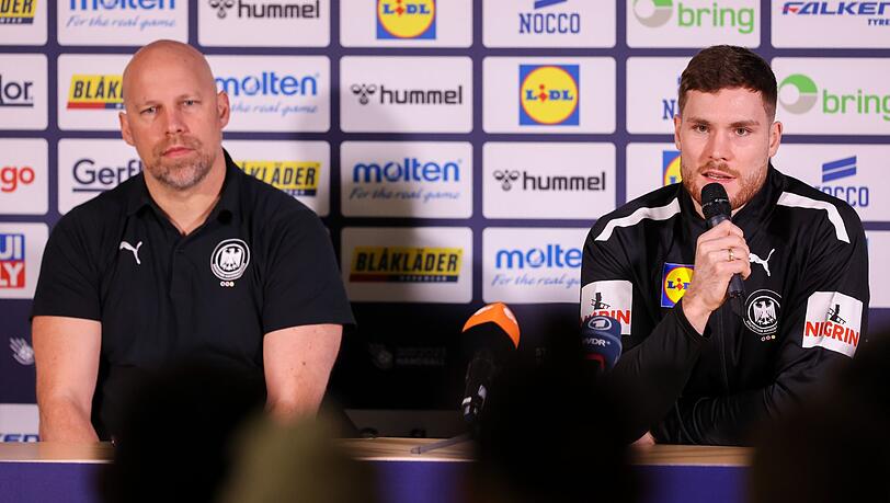 Axel Kromer (l) und Kapitän Johannes Golla sitzen während einer Pressekonferenz auf dem Podium.