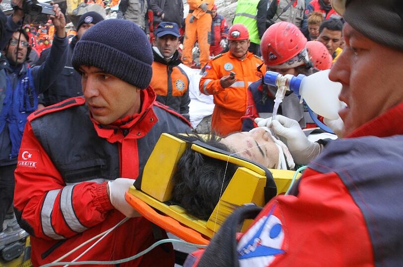 Rettungskräfte bergen eine Mitarbeiterin der japanischen Vereinigung für Hilfe und Rettung.