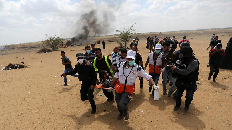 Palästinenser tragen einen verletzten Demonstranten bei Protesten für die Rückkehr in ihre Heimat anlässlich des Nakba-Tags.