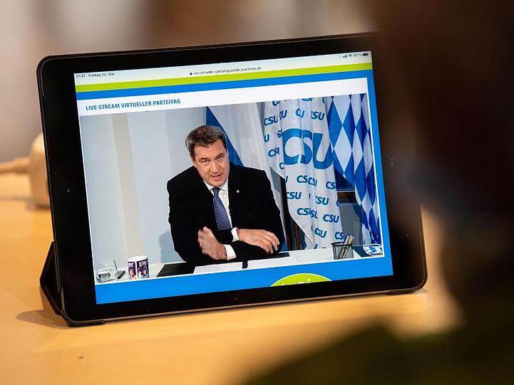 Ein Journalist beobachtet den Livestream vom CSU-Parteitag, bei dem Parteichef Markus Söder spricht.