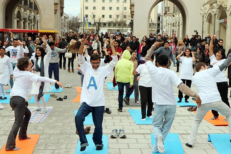 Hopsen und Dehnen in der Fußgängerzone: Am Stachus haben sich Yoga-Fans zu einem Flashmob unter freiem Himmel verabredet. Die Bilder.