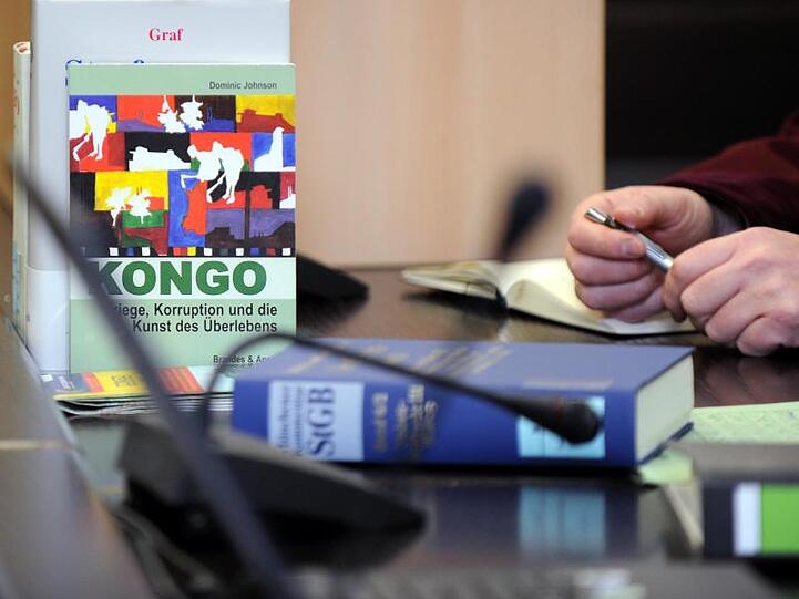 In einem Gerichtssaal im OLG Stuttgart steht neben juristischer Literatur auch ein Buch über "Kriege, Korruption und die Kunst des Überlebens im Kongo".