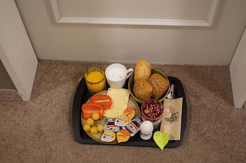Jeden Morgen liefern Hotelmitarbeiter ein Frühstückstablett vor dieZimmertür - mit Semmeln, Joghurt, Ei, Orangensaft und Käse.