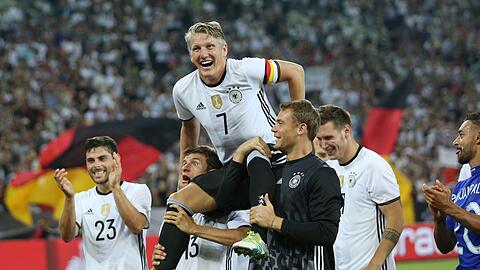 Bastian Schweinsteiger wird nach seinem letzten L&auml;nderspiel gegen Finnland von Thomas M&uuml;ller (l) und Manuel Neuer (r) auf Schultern getragen. (Archivbild)