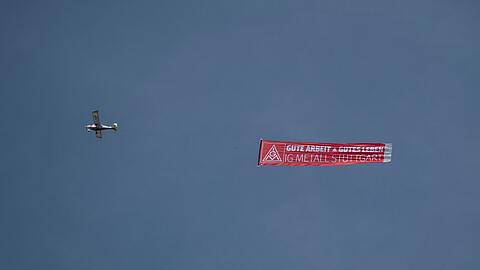 Ein Flugzeug mit einem IG-Metall-Banner fliegt &uuml;ber das Porsche-Stammwerk in Zuffenhausen.