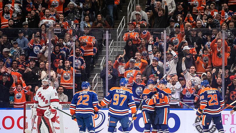 Frederik Andersen (31) von den Carolina Hurricanes sieht zu, wie die Edmonton Oilers um Leon Draisaitl (29, r) ein Tor feiern.