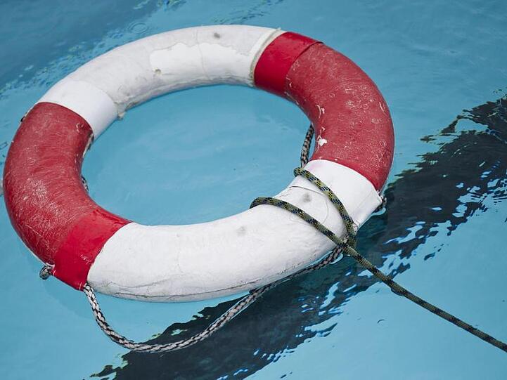 Ein Rettungsring liegt im Becken eines Freibads. Foto: Ole Spata/ZB/dpa/Symbolbild