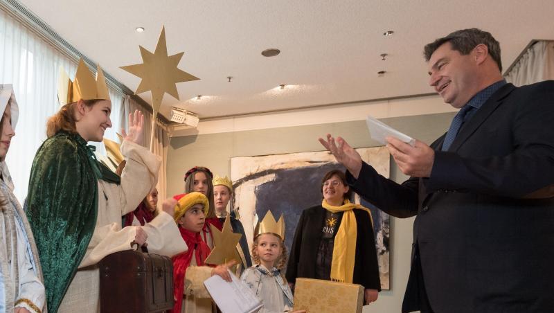 Der bayerische Ministerpräsident Markus Söder (CSU) überreicht Briefumschläge mit Spenden an die Sternsinger. Foto: Peter Kneffel Der bayerische Ministerpräsident Markus Söder (CSU) überreicht Briefumschläge mit Spenden an die Sternsinger. Foto: Peter Kneffel