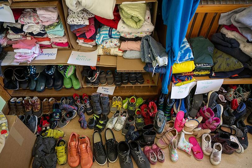 Gespendete Kinderkleidung liegt in einem Raum des Pfarrverband Haidhausen.
