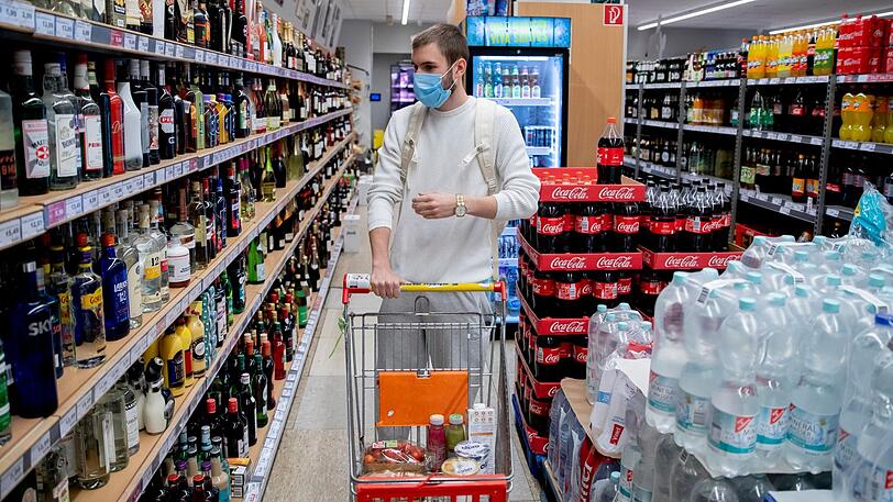 Ein Mann kauft &ndash; mit Mundschutz &ndash; im Supermarkt ein.