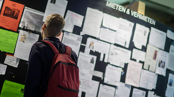 Ein Student betrachtet die Wohnungsanzeigen am Schwarzen Brett in der Mensa der Ludwig-Maximilians-Universität in München. (Archivbild)