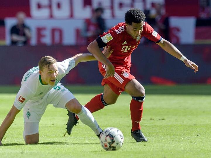 Bayerns Serge Gnabry (r.) im Zweikampf mit Bremens Ludwig Augustinsson. Foto: Matthias Balk/Archivbild