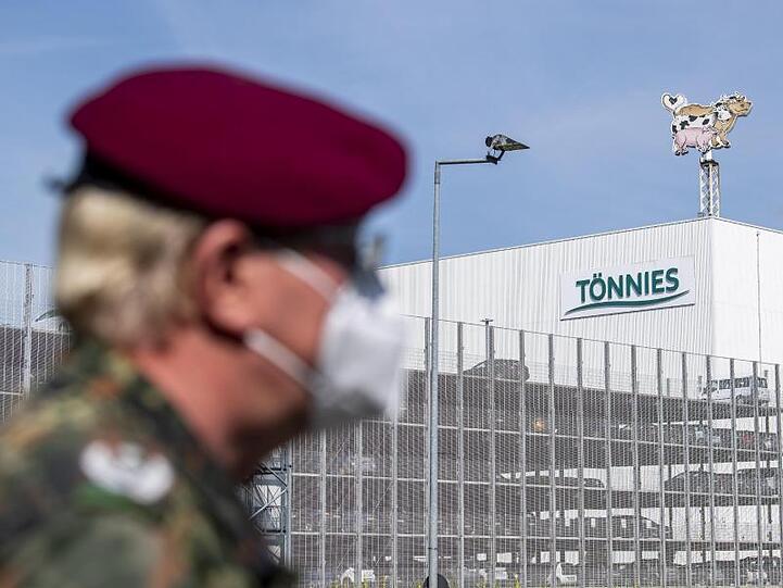 Ein Soldat auf der Bundeswehr steht vor dem Gebäude der Fleischfabrik Tönnies in Rheda-Wiedenbrück. Die Bundeswehr unterstützt bei Tests der Mitarbeiter auf das Coronavirus.